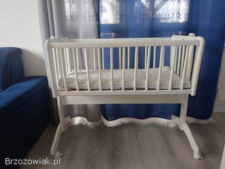 Drewniana,  biała kołyska na kółkach